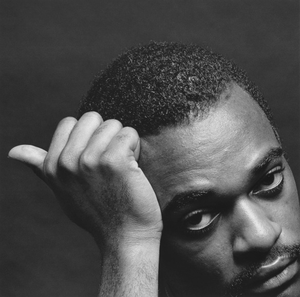 Close-up of a man rest his head on his hand and looking into to camera.