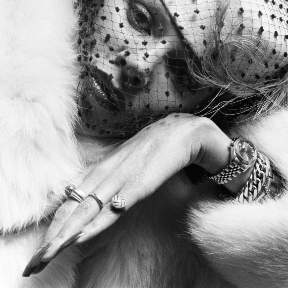 Aira wearing fur coat, lots of jewelry, and makeup.