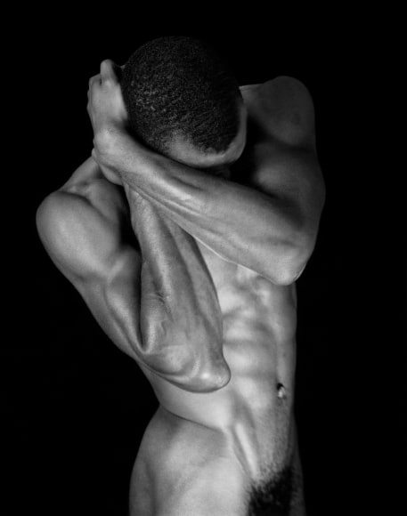 Black Male nude covering his face.