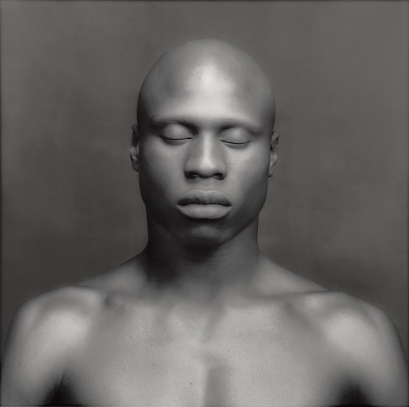 Ken Moody nude from the chest up, facing camera, eyes closed.