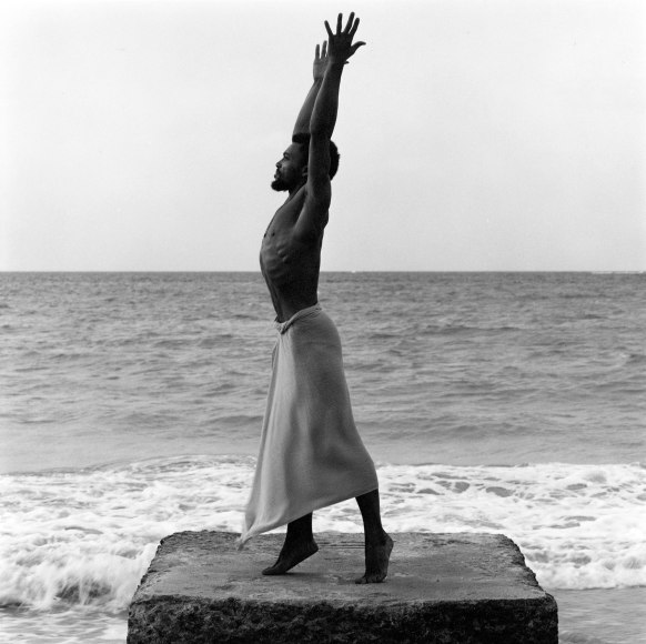 Milton Moore in profile with arms outstretched.