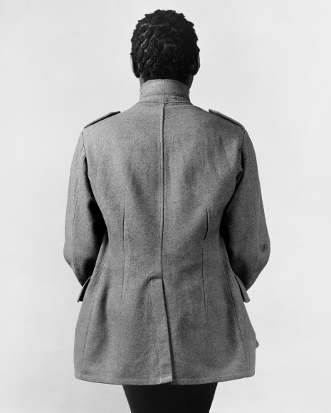 Black male in overcoat facing away from camera.
