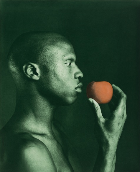 Ken Moody looking forward and holding an apple.