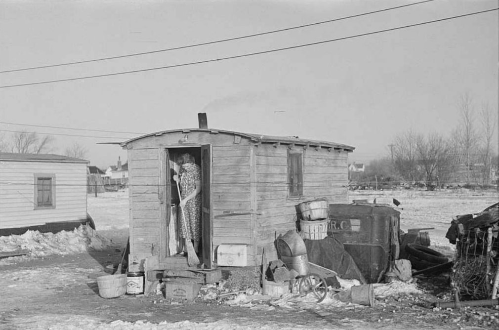 Mrs. Charles Benning sweeping steps of shack in &quot;Shantytown,&quot; Spencer, Iowa, 1936, &nbsp;