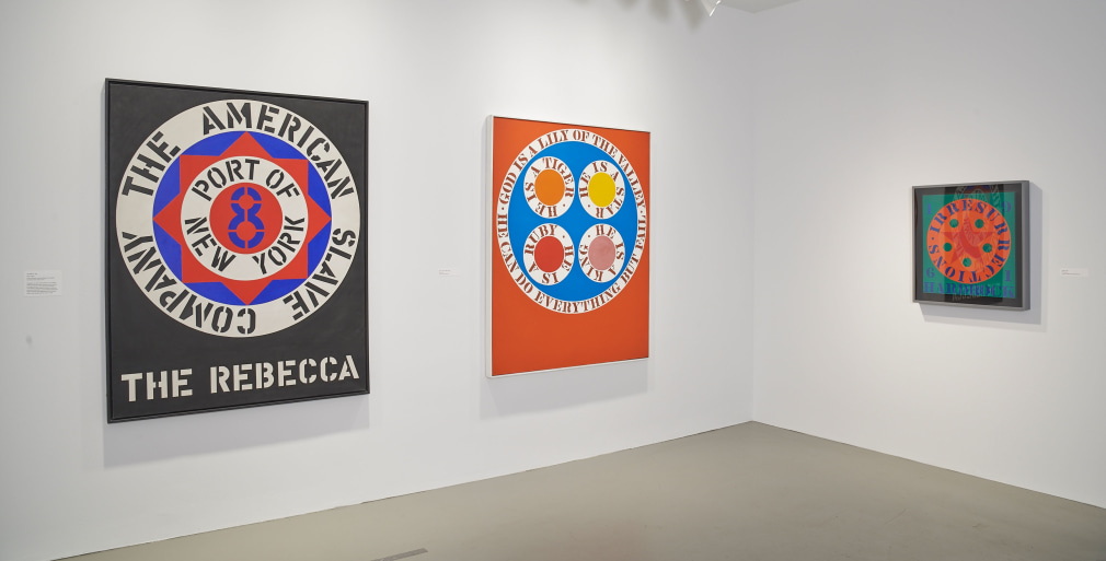 Installation view of Robert Indiana: Beyond LOVE, Whitney Museum of American Art, New York, September 26, 2013&ndash;January 5, 2014. Left to right, The Rebecca (1962), God Is a Lily of the Valley (1961&ndash;62), and Hardrock (1961), &nbsp;