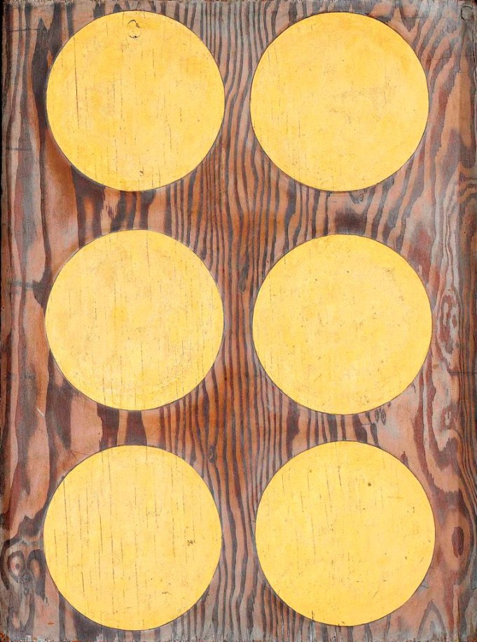 Three horizontal rows of two golden orbs on a plywood background