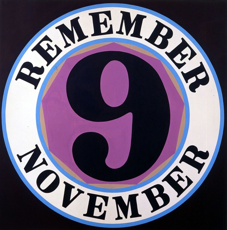 A 60 inch square canvas with a black ground dominated by a circle containing a purple nonagon with a black numeral nine surrounded by a white ring with blue outlines. Within the ring the painting's title, &quot;Remember November,&quot; is painted in black letters.