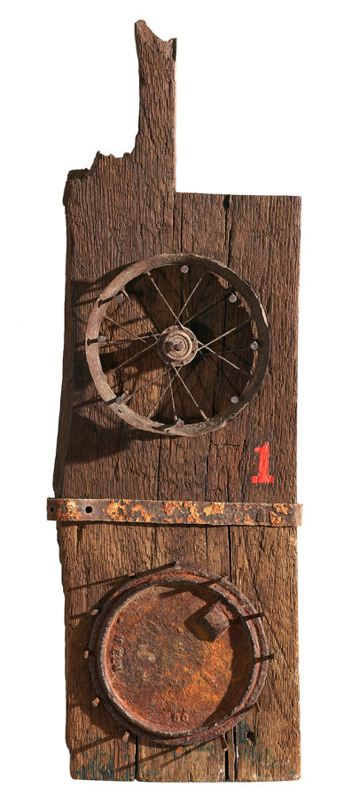 Sun and Moon, a sculpture consisting of a weathered rectangular piece of wood with a tenon. On the front bottom half is a rusted stove lid, above this, dividing the sculpture in two halves, is a rusted iron bar. A rusted iron wheel is in the upper half of the sculpture, and to the right, below the wheel, is a painted red numeral one.
