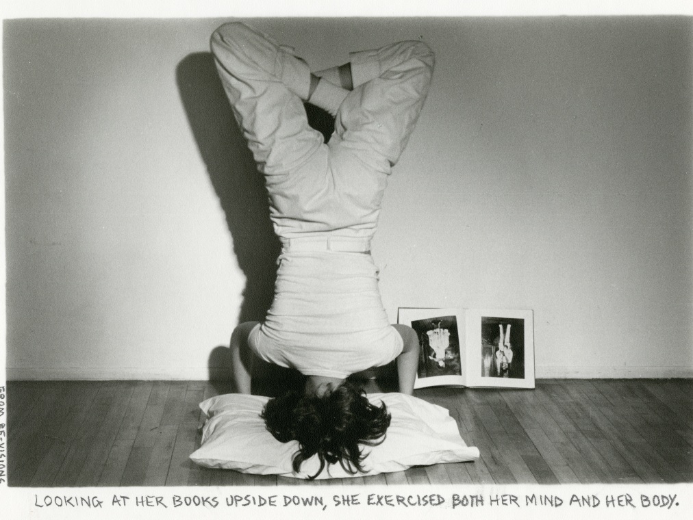 A woman does a headstand and looks at a book that is upside down against the wall across from her. A capture under the image reads, "Looking at her books upside down, she exercised both her mind and her body."