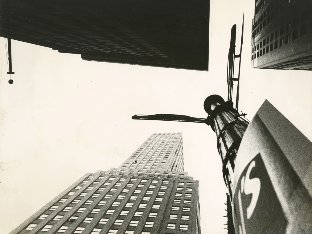 A Wall Street intersection is shown as the camera looks upward and shows the tops of three buildings.