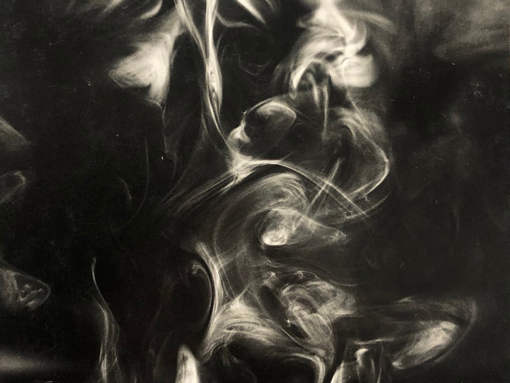Smoke rises elegantly against a black backdrop.