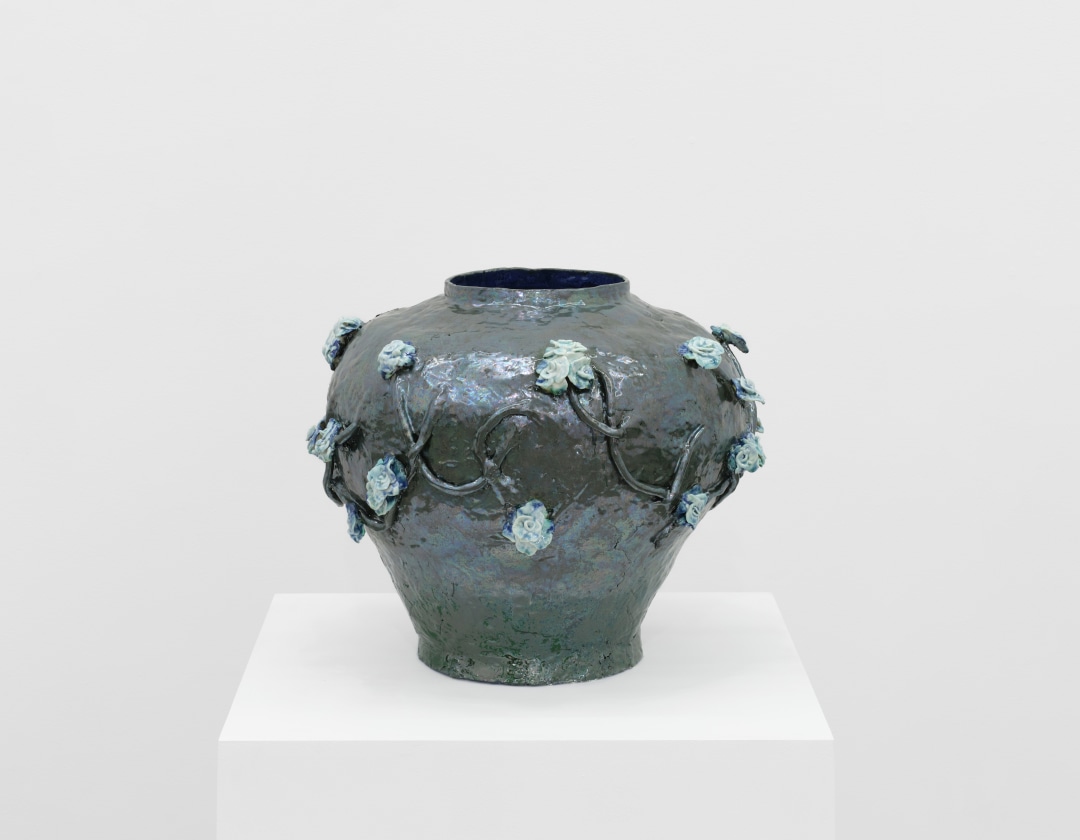 Detail of a sculpture by LaRissa Rogers of a ceramic floral vessel.