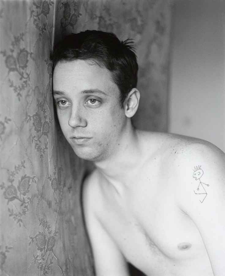 Man leaning on mattress by Stephen Barker