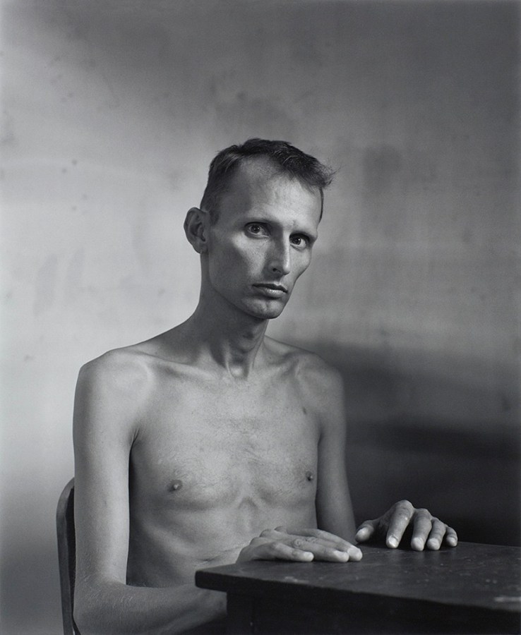 Man with hands on table by Stephen Barker