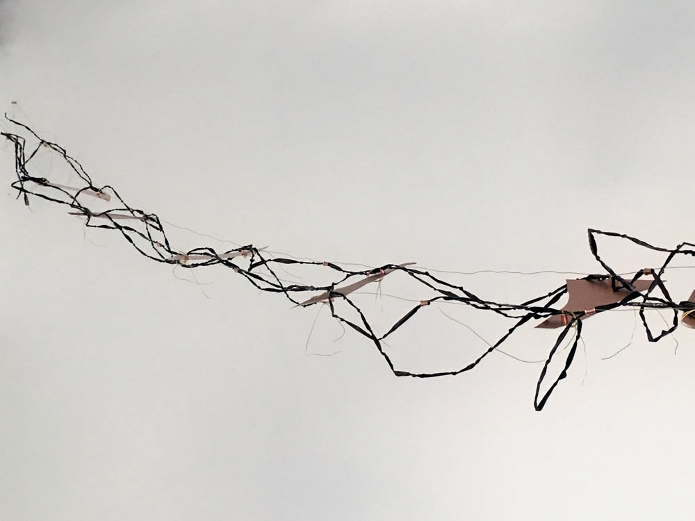 Lisa C. Soto My broken bridge, the gap in you saddens me, makes me want to repair you, repair us. Layers of our stories,our truths, our heartbreak embedded in my magnetized lines. All of our joy and pain compressed into these knots. How do we bridge this gap? Let&rsquo;s create a path above this ocean. Let&rsquo;s create a force field., 2018  Magnetic tape, copper, brass wire  336 x 8 in.