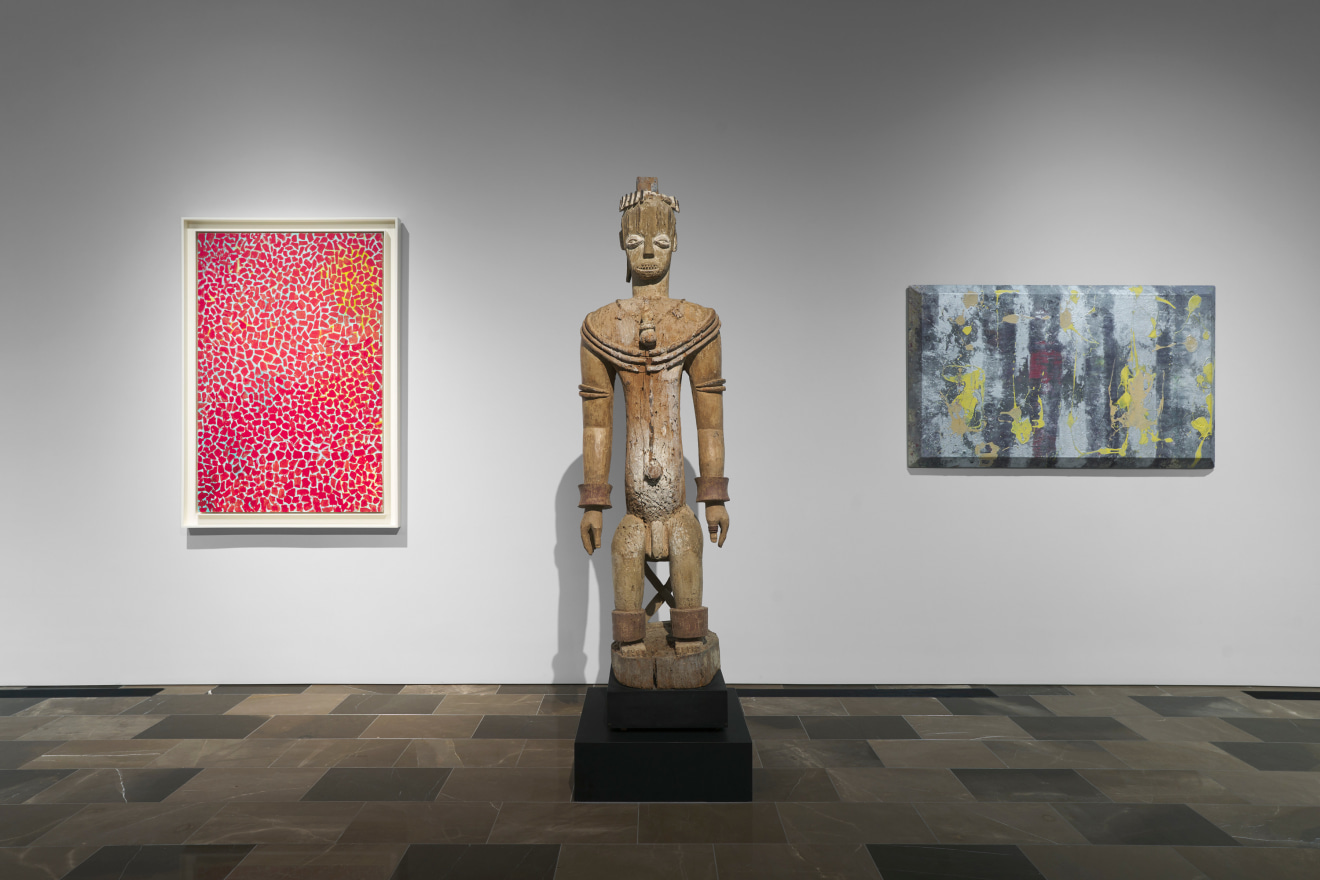 A 1976 painting by Alma Thomas,&nbsp;Red Rambling Rose Spring Song&nbsp;(left), and a 1967 canvas by Sam Gilliam,&nbsp;A Glistening, flank an Urhobo male figure. Courtesy Adam Lindemann (New York) and Bernard de Grunne (Brussels).