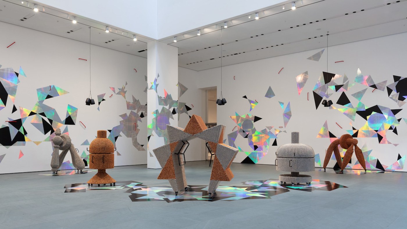 Haegue Yang (Korean, b. 1971) is known for genre-defying, multimedia installations that interweave a range of materials and methods, historical references, and sensory experiences. Handles, Yang’s installation commissioned for MoMA’s Marron Atrium, features six sculptures activated daily, dazzling geometries, and the play of light and sound, to create a ritualized, complex environment with both personal and political resonance., 