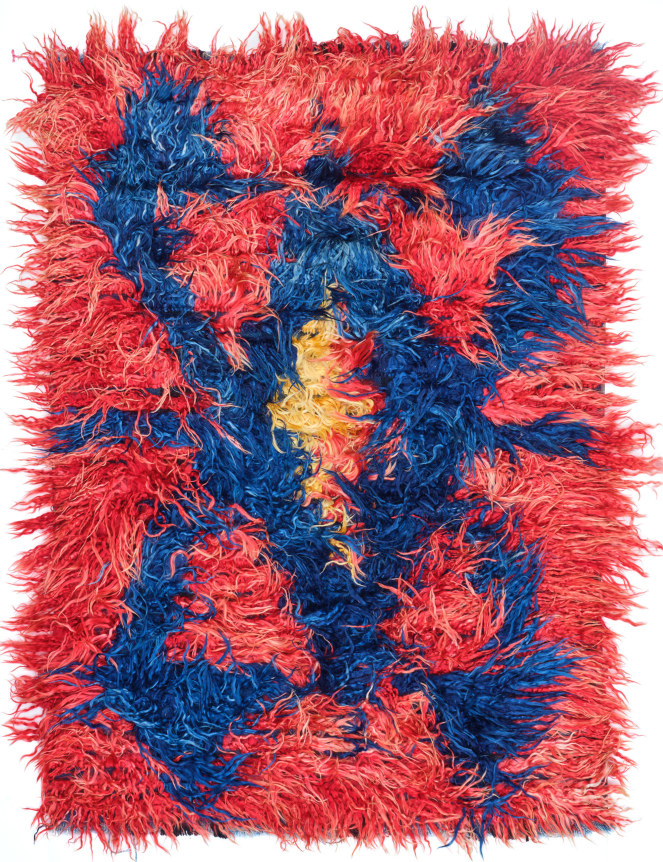 bright red konya tulu stringy shag rug. the design features a spider-like motif in the center