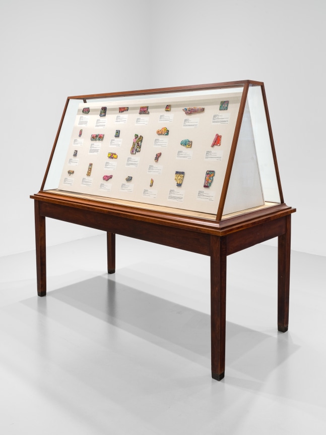 The Invisible Enemy Should Not Exist (Vitrine 2 - ivories), 2023, Glass vitrine, Middle Eastern food packaging and newspaper, glue