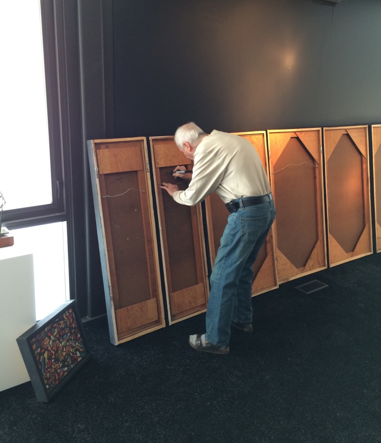 Image of Fred Martin signing untitled acrylic and pastel works at Caldwell Gallery Hudson.