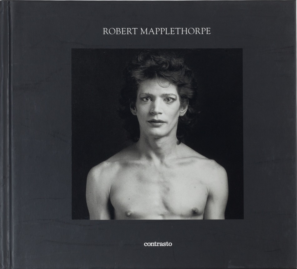 Self-portrait, shirtless with makeup, with a black frame around image and white text at top of the page.