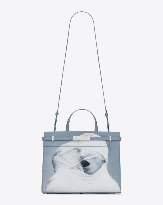 Purse with a photograph of two men wrapped together in white gauze.