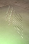 Tauba Auerbach A Flexible Fabric of Inflexible Parts, 2015 borosilicate glass on table of aluminum, wood and paint 11 helical components each approximately 3 x 3 x 31 1/2 inches (7.6 x 7.6 x 80 cm). Overall dimensions: 3 x 78 x 25 inches (7.6 x 198.1 x 63.5 cm) table: 23 1/2 x 84 x 84 in. (59.7 x 213.4 x 213.4 cm)