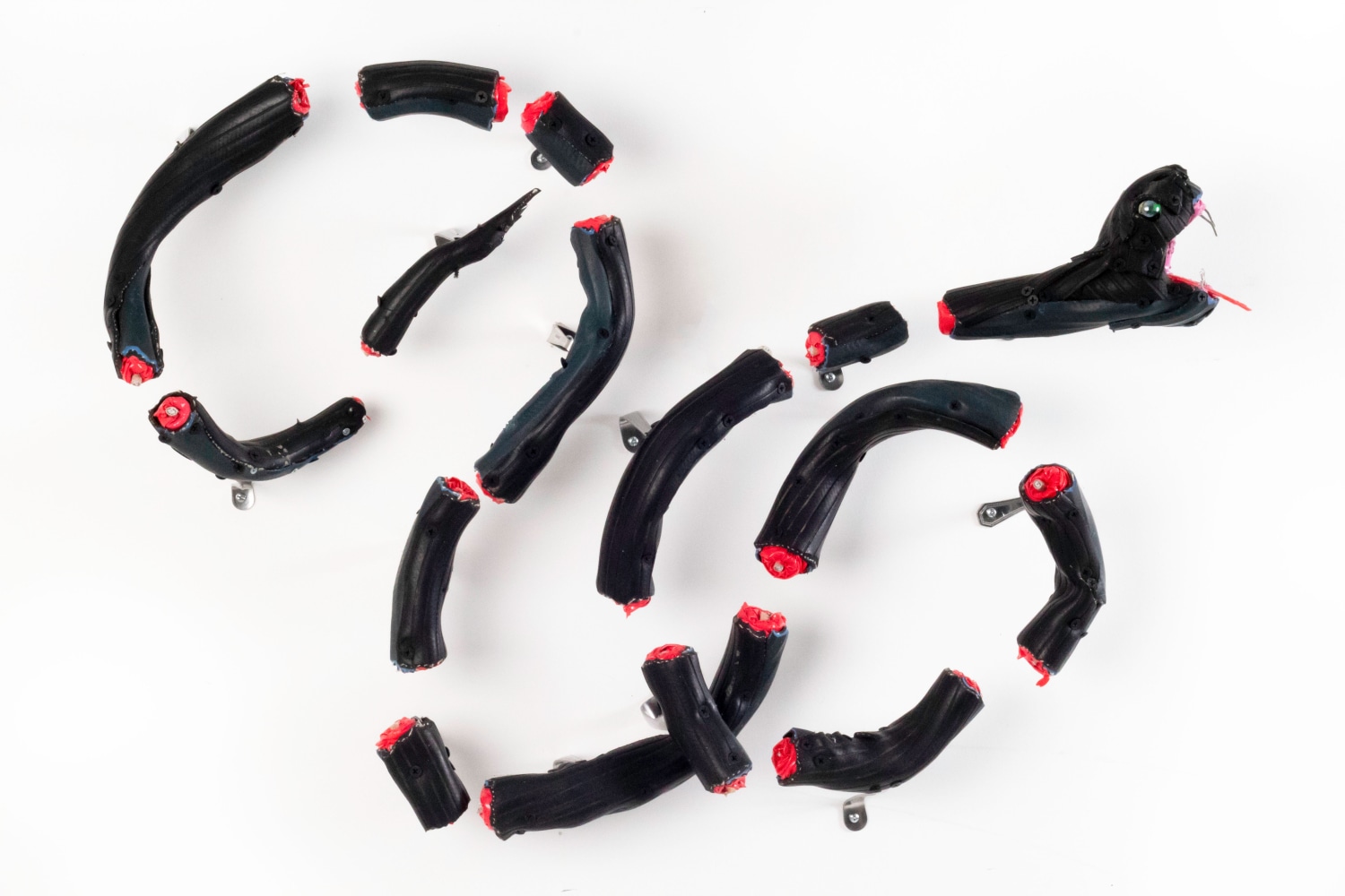 The Long Division, 2018, installed (16 individual pieces of variable size) garden hose, coax cable, screws, metal spoons and forks, glass marble, plastic table cloth, hot glue, 28 x 6 x 22 inches