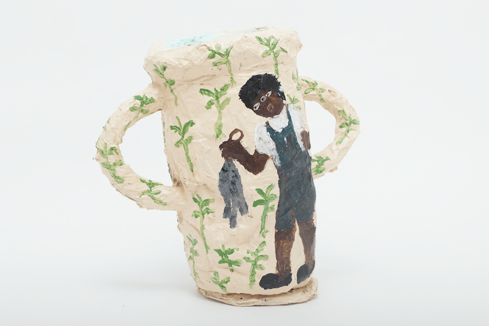 Sculpture with handles painted with a little boy holding a fish