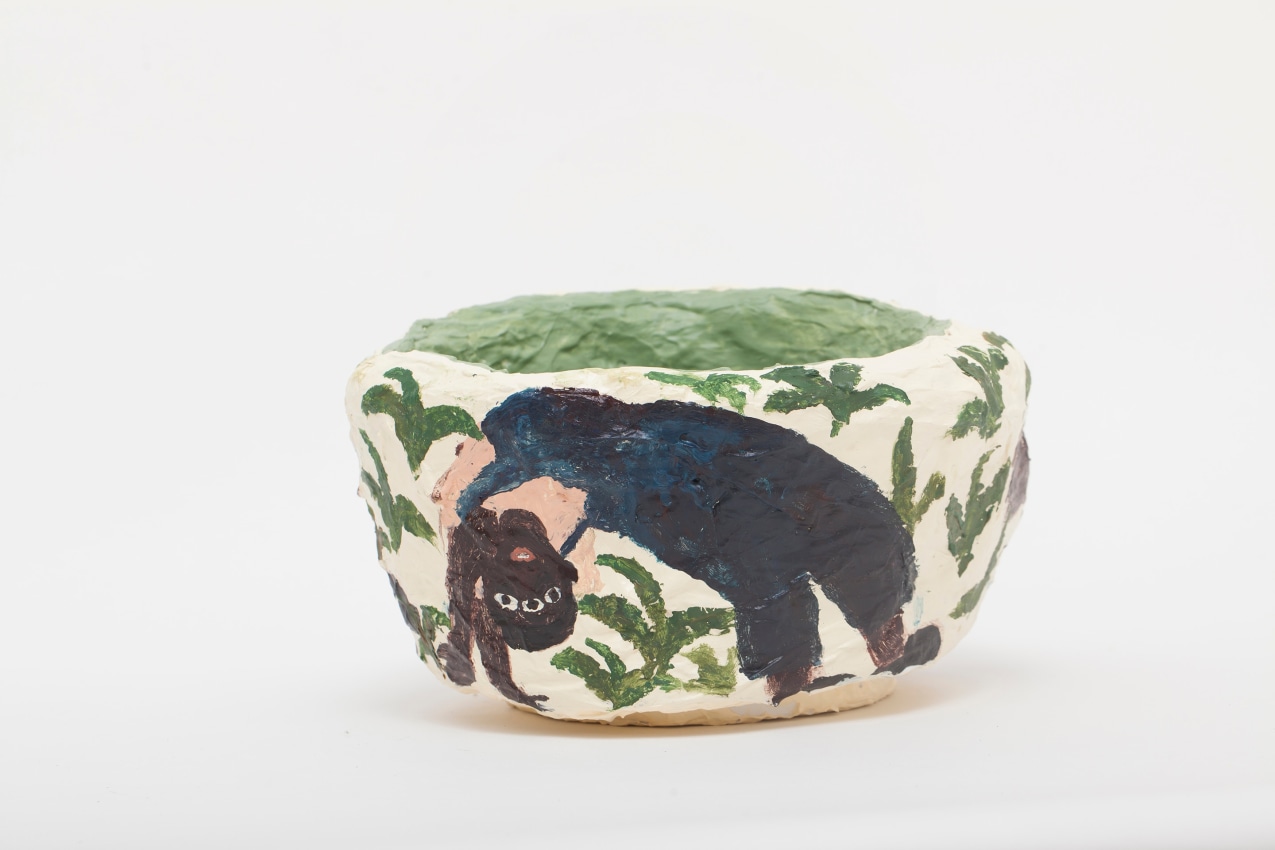 Sculpture with Sanbras in a bridge pose with three eyes surrounded by plants