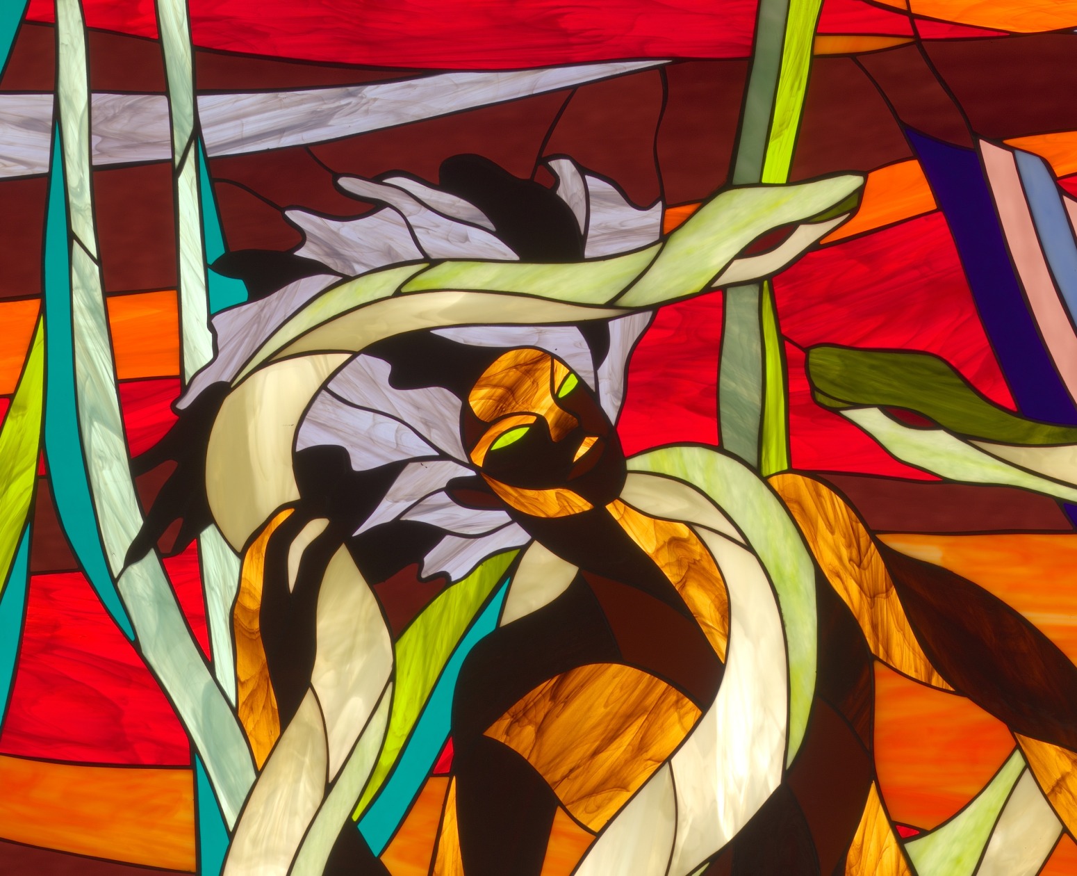 stained glass image of a black mermaid intertwined with serpants