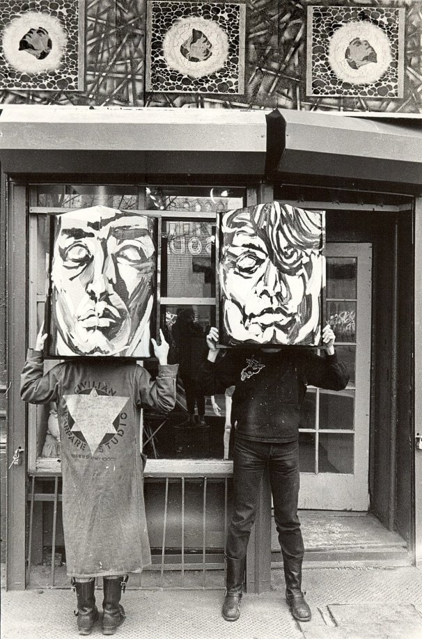 Civilian Warfare directors Dean Savard and Alan Barrows with Luis Frangella&rsquo;s masks, 1984, East Village NYC, with David Wojnarowicz&#039;s frieze featuring Peter Hujar stencil portraits on top, photography by Marion Scemama. Courtesy Alan Barrows.