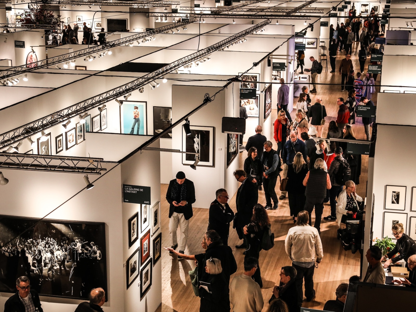 A photograph of a crowded aisle at The Photography Show 2024, photographed in color from above.
