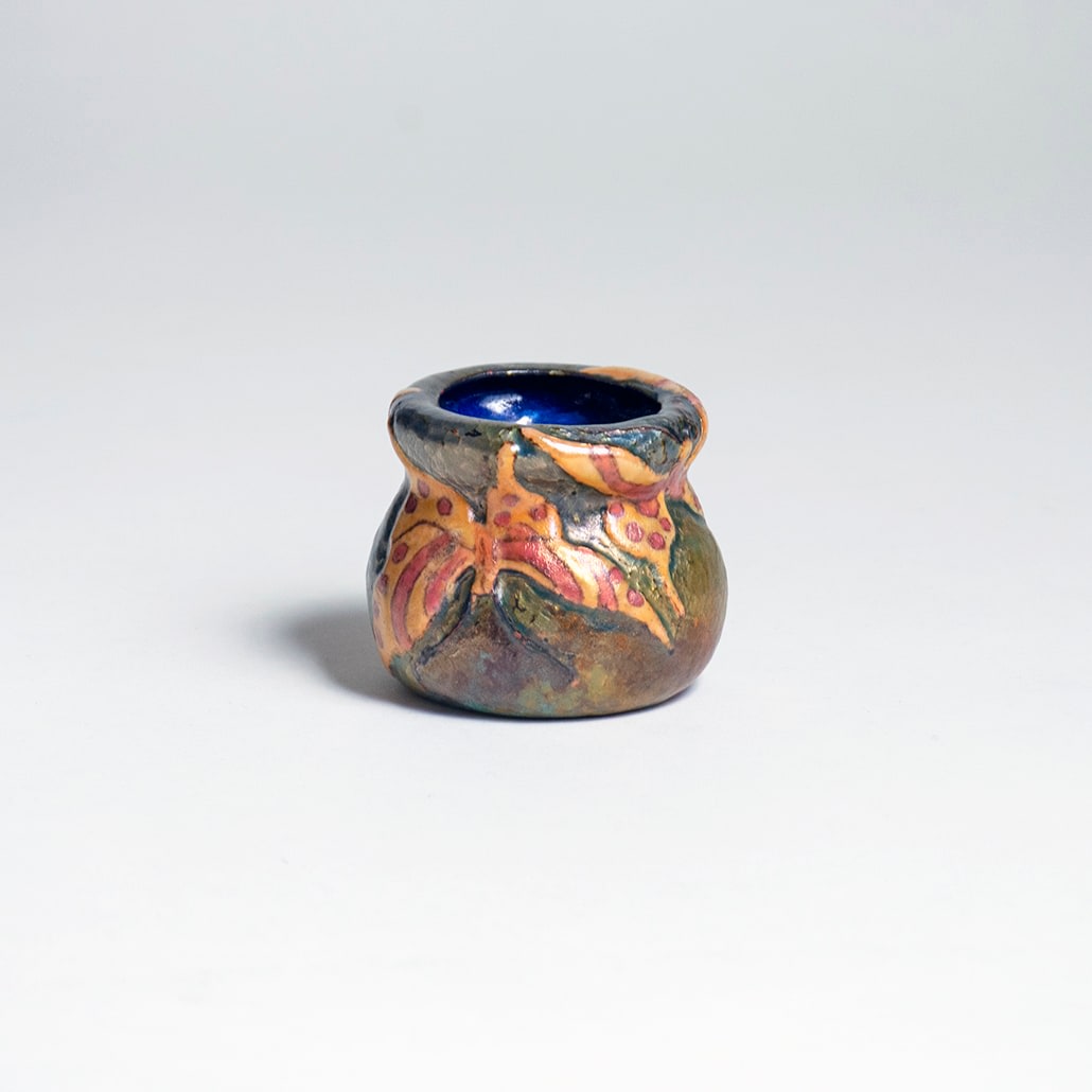 a rare enamel on copper vase by tiffany studios depicting butterflies against a hammered background with iridescent surface