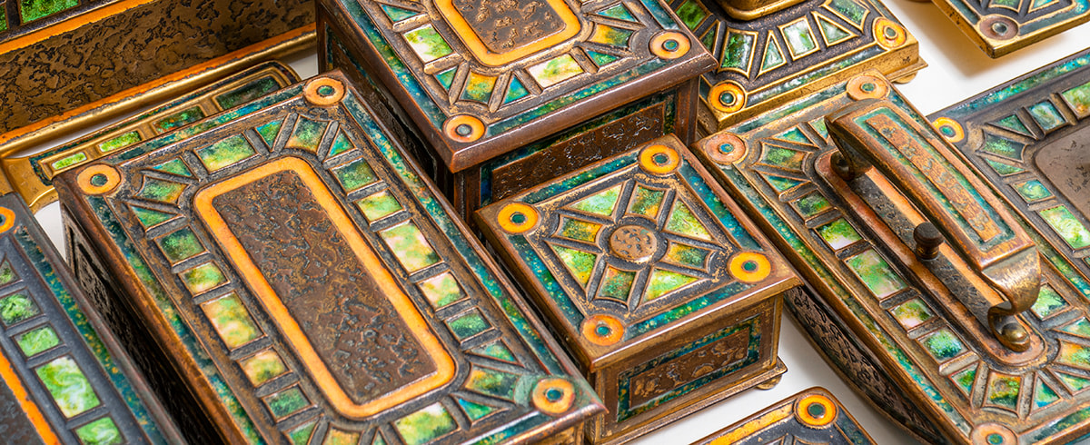 a bronze desk set by tiffany studios in the art deco or art moderne pattern, with rectilinear recesses with inset enamel in variegated green/yellow tones