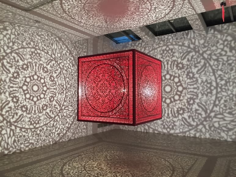 Anila Quayyum Agha All the Flowers Are for Me (Red - Ed. of 2) 2016 Laser-cut red lacquered stainless steel and bulb 60 x 60 x 60 in.