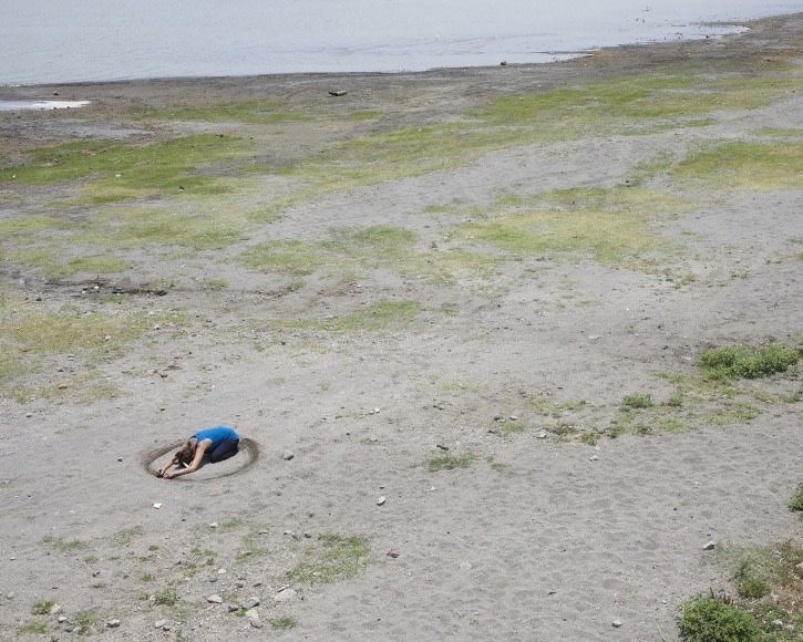 Birds-eye view of woman in the sand on the beach.