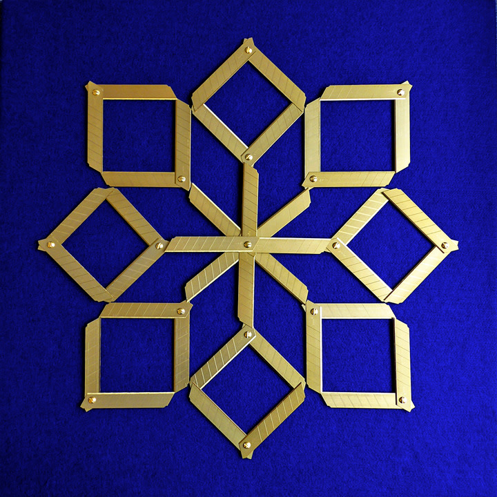 Abdullah M. I. Syed Margin of Error - Rosette on Blue, 2017 Titanium utility knife blades, brass, stainless steel, felt and tempered hardwood 23 x 23 in