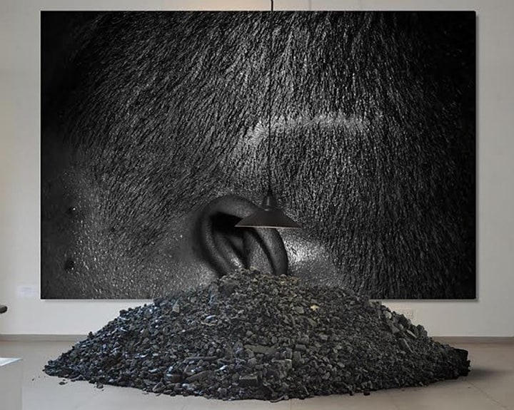 A pile of coal lit by a lamp, as well as a close-up picture of the side of a man's head with a scar from torture during the Sri Lankan civil war.