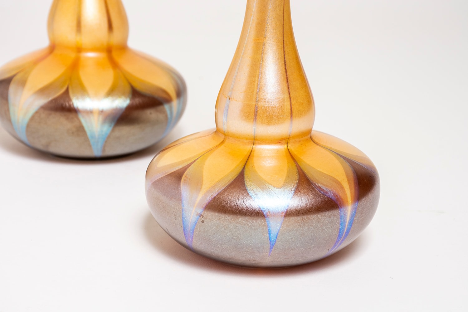 detail of a pair of blown tiffany favrile glass vases with iridescent detail