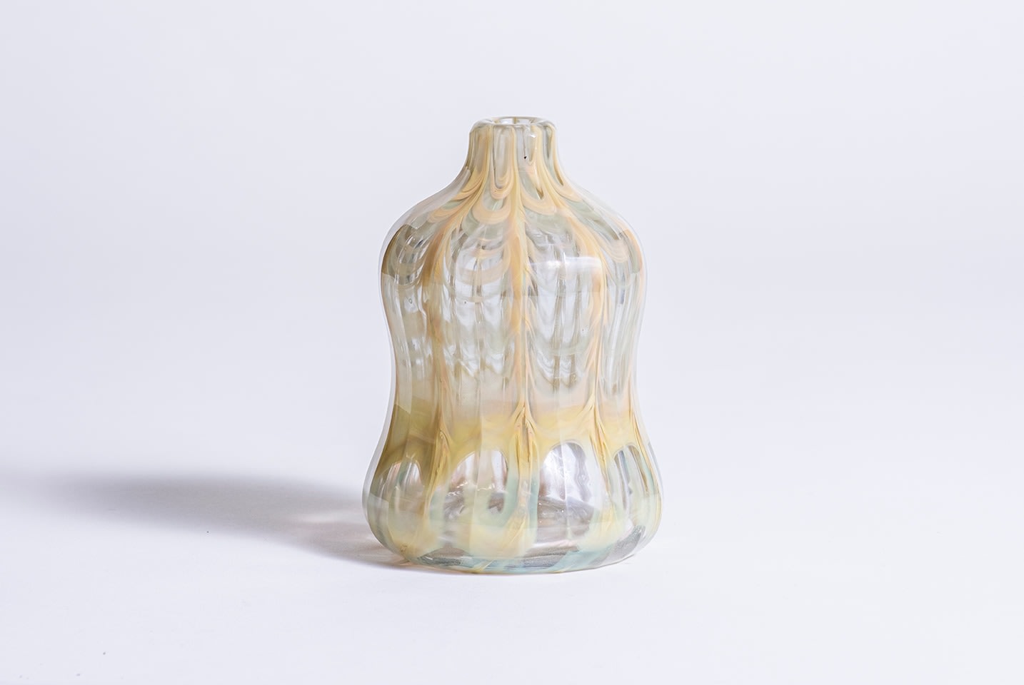 an early tiffany favrile glass paperweight agate vase, with internal decoration of agate-style stoneware inspired design in variegated creamy yellow encased within thick clear glass, the vase of waisted cylindrical form with thin neck