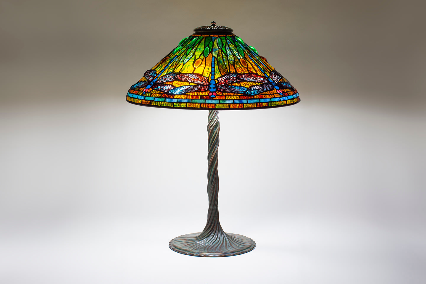 a tiffany dragonfly table lamp with leaded glass shade depicting blue dragonflies, paired with a twisted vine bronze tiffany lamp base