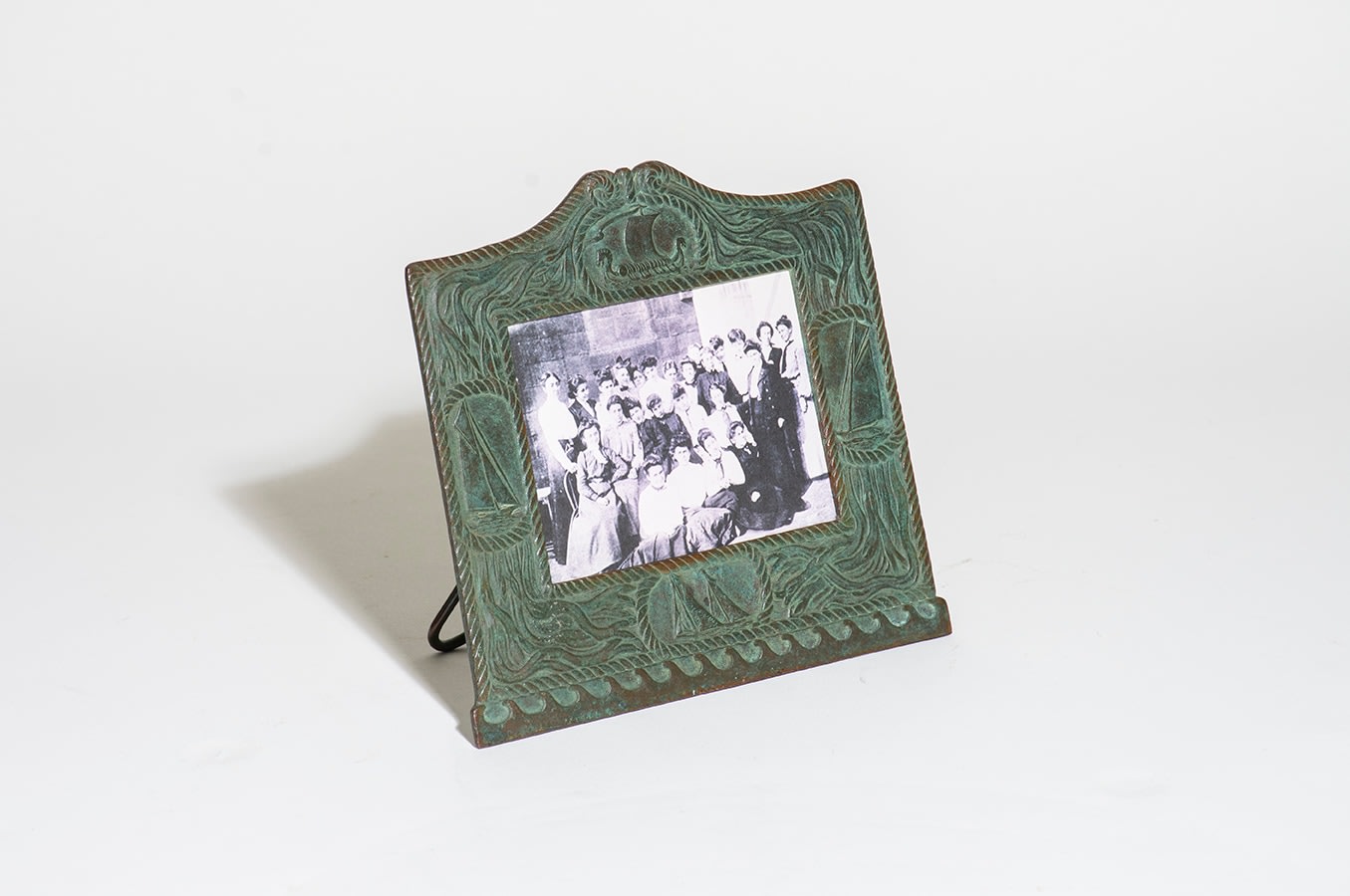 a low rectangular calendar frame from tiffany studios &quot;nautical&quot; desk set, the bronze in a green patina, the frame borders depicting maritime motifs including kelp, rope, and depictions of various sailing ships