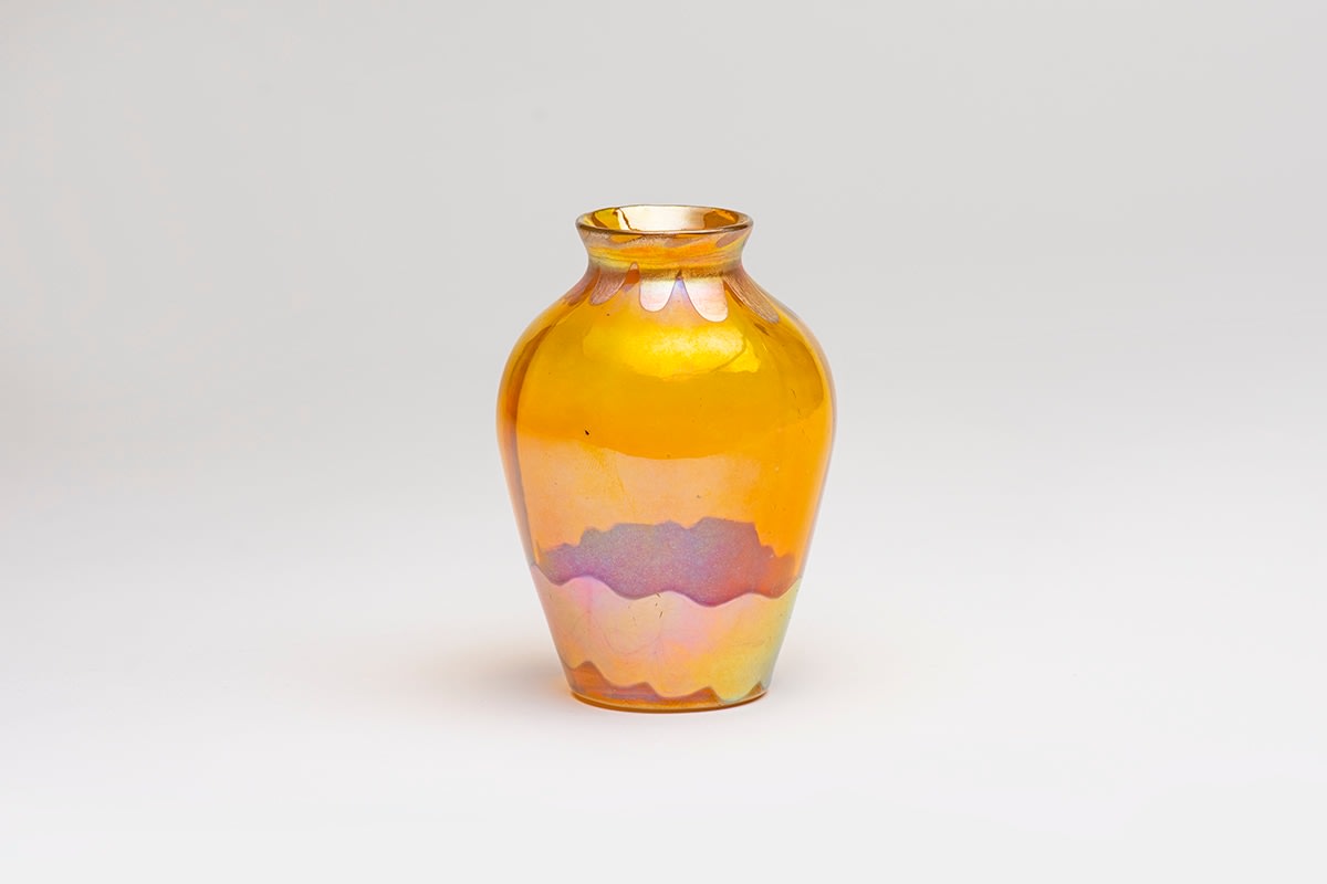 an early blown tiffany favrile glass cabinet vase, formed by vibrant yellow transparent glass, decorated at the base with thick band of gold iridescent wave motif, at the neck a series of pulled motifs in gold iridescent, the opaque decoration contrasting with the transparent body of the vase