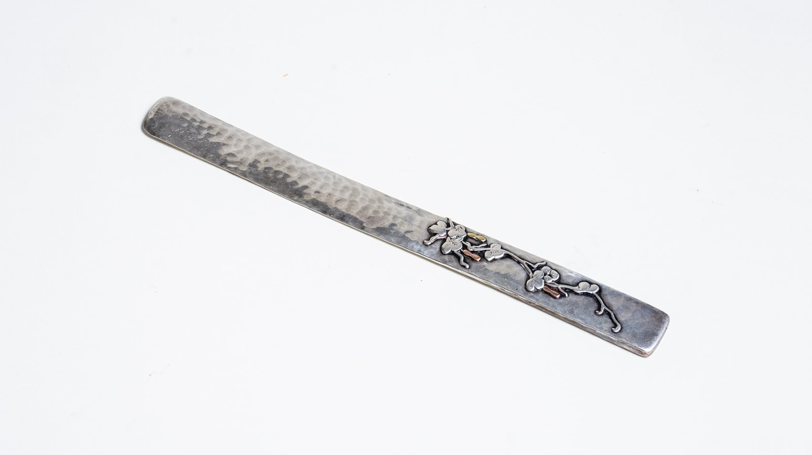 a thin rectangular paper knife in sterling silver with squared edges, the handle with. mixed metal decoration of squash or gourds in copper and bronze with a thin swirling vine and leaves in raised silver