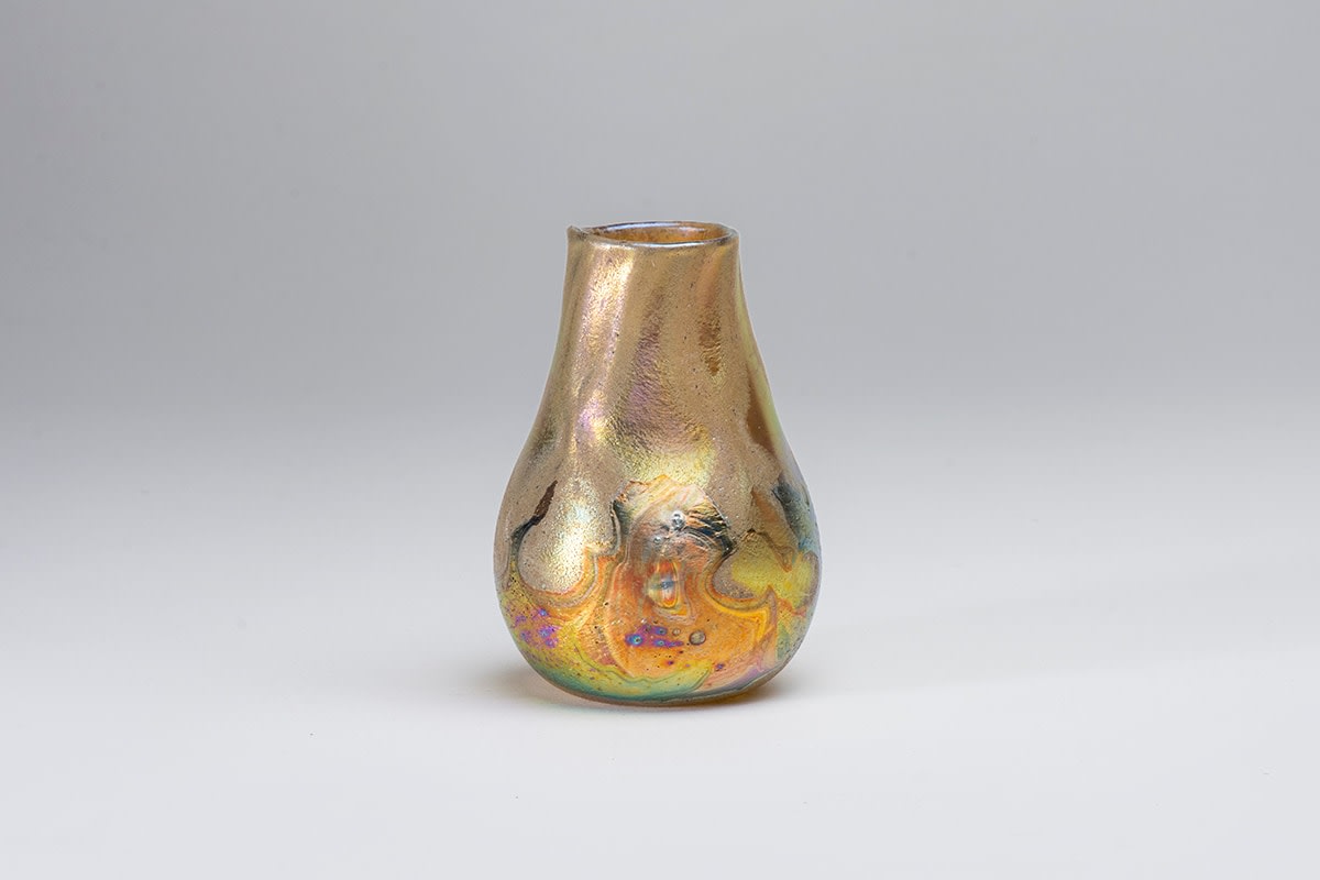 an authentic tiffany favrile glass cypriote vase, a gold iridescent irregular pear shaped cabinet vase, the rounded body and tapered cylindrical neck formed by gold iridescent tiffany glass with irregular pitted surface texture and rainbow iridescence reminiscent of ancient glass