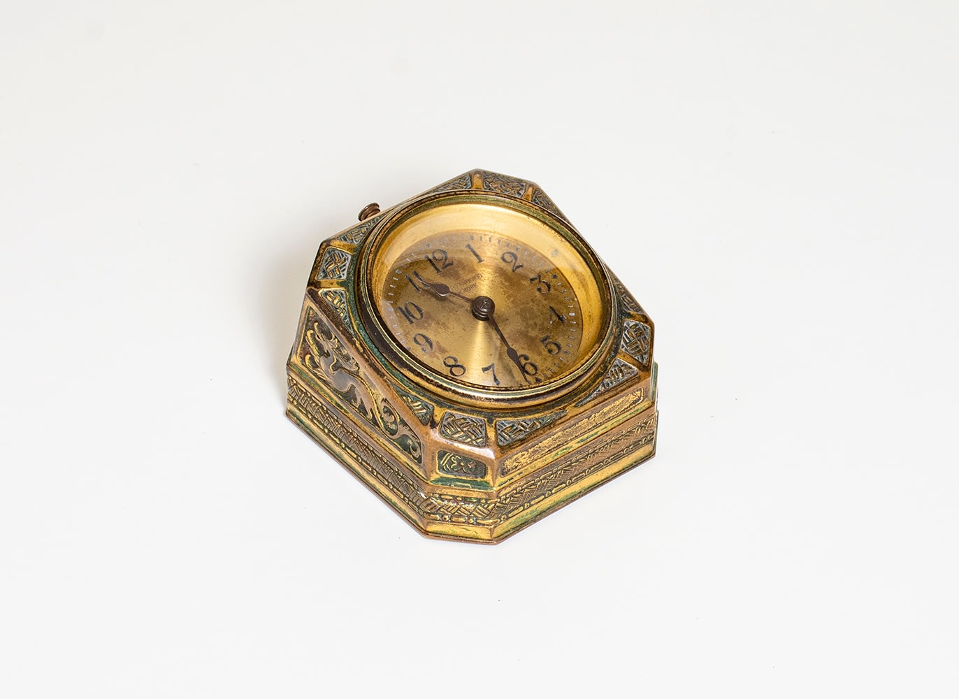 a gilt bronze desk clock by tiffany studios from the spanish desk set, with elaborate surface decoration
