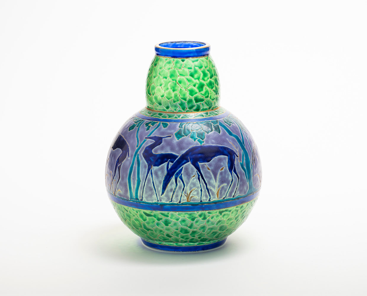 an enameled vase, the top and bottom sections in a green faceted gem-like pattern, with a horizontal frieze decoration at the middle in pale lavender with stylized art deco gazelles in deep blue with gold outlines