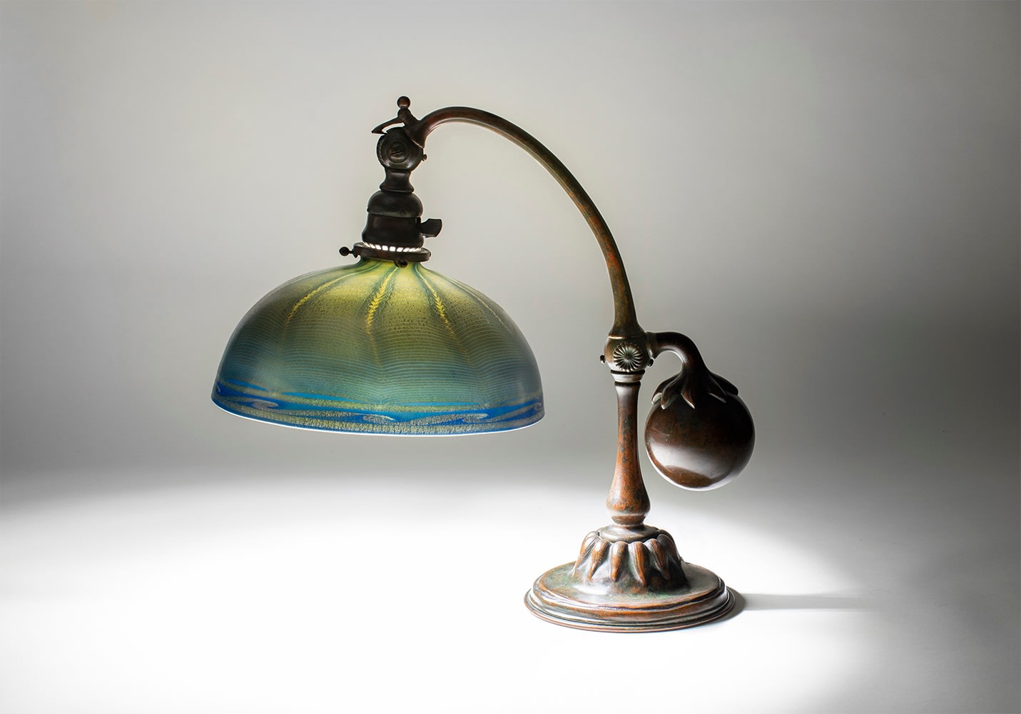 a tiffany desk lamp with bronze counter-balance or &quot;balance weight&quot; base, paired with a blown tiffany favrile glass &quot;damascene&quot; shade in dark blue with iridescent decoration