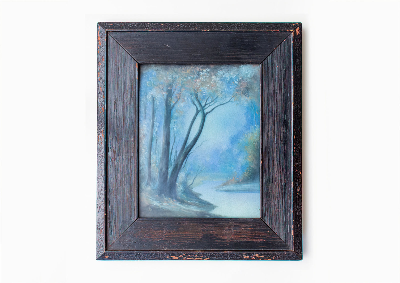 a glazed ceramic plaque in period wooden frame dating to 1914 by american art pottery company rookwood, the scene of a hazy landscape in the ohio river valley with small creek and trees, in the scenic vellum glaze known for tonalist style landscapes